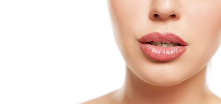 beautiful female lips with lip gloss on white background