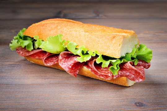 Half baguette sandwich with salami and lettuce