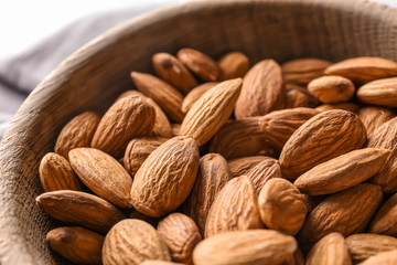 Fresh almonds in wooden bowl, closeup