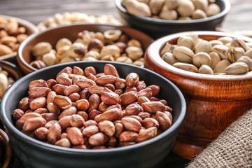 Bowls with different nuts on table, closeup