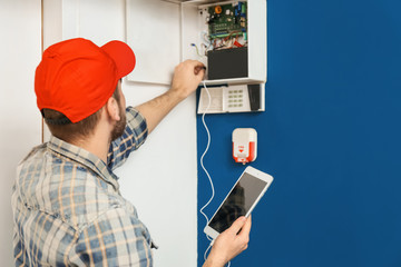 Young electrician installing alarm system