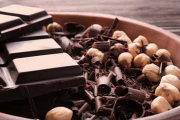 Plate with chocolate curls and hazelnuts, closeup