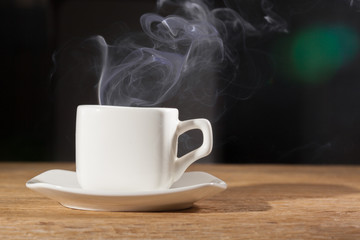 vapor  over a cup of morning breakfast on an oak table dark background