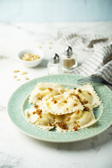 Homemade ravioli with fried bread crumbs, soft cheese and pine nuts