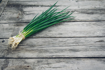 Fresh green onion on a wooden background. Top view. Free space for your text.