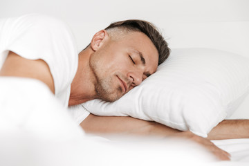 Fototapeta na wymiar Handsome man sleeping in bed