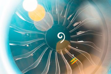 Close up of turbojet of aircraft turbine engine fan civil with a gradient of colors from cold to warm sun glare lights.