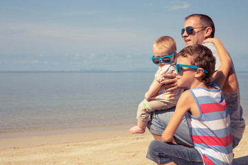 Father and children  playing on the beach at the day time.