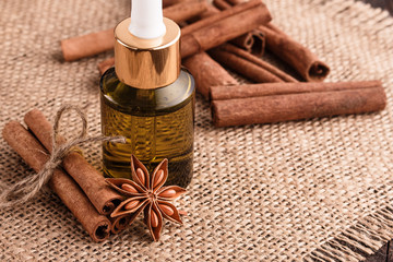 Fototapeta na wymiar Cinnamon essential oil on a wooden background