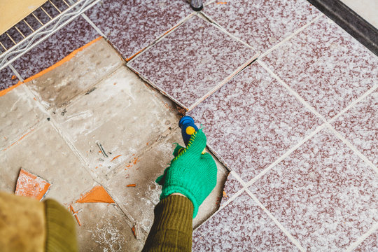 Hands take tile with chisel
