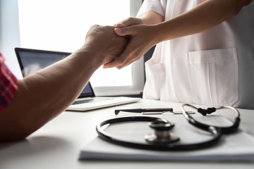 Senior male patient handshaking with Doctor female.