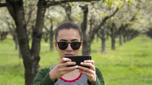 Young caucasian woman with sunglasses taking photos on her phone