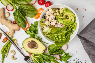 Vegan food flat lay. Buddha bowl with tofu, rice, avocado and vegetables. Healthy vegan food concept.