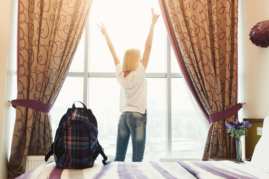 Woman standing near the window in hotel room