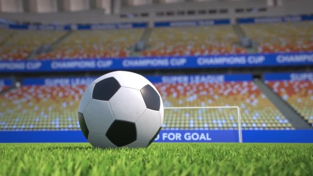Camera moves towards and around a football lying in the grass in an empty soccer stadium. With go for goal slogan behind the goal. Wide angle view. Realistic high quality 3d animation.