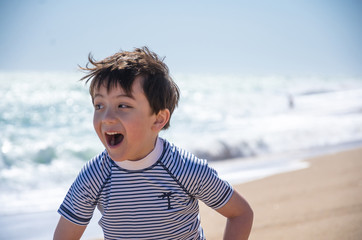 A portrait of  a young boy on a beach while on holiday.