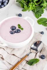 Sweet creamy blueberry soup, vegan summer food, white marble background copy space