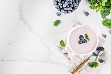 Sweet creamy blueberry soup, vegan summer food, white marble background copy space