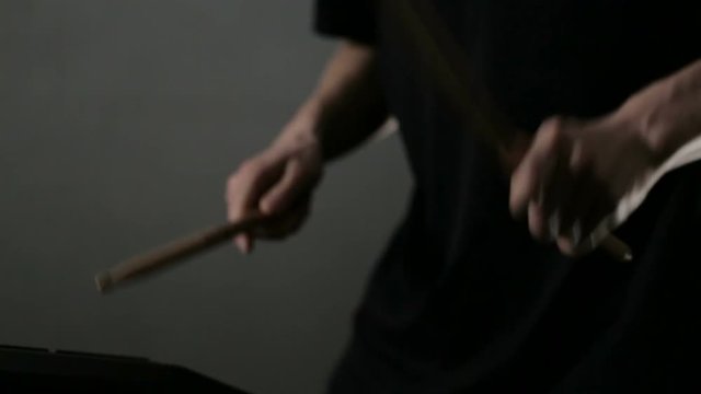 Close up shot of man's hands drum sticks on sampler and electronic pads