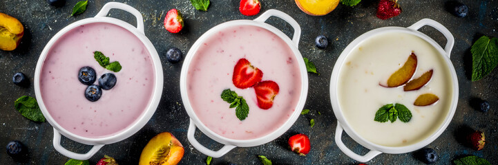Various sweet creamy fruit & berry soups - strawberry, peach, blueberry, dark blue concrete...