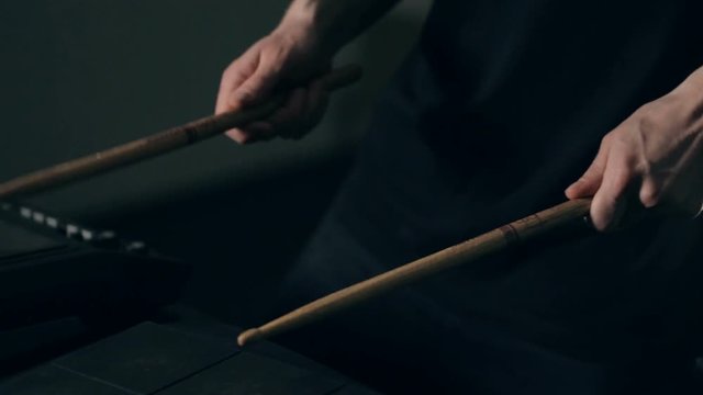Close up shot of man's hands drum sticks on sampler and electronic pads