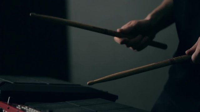 Close up shot of man's hands drum sticks on sampler and electronic pads