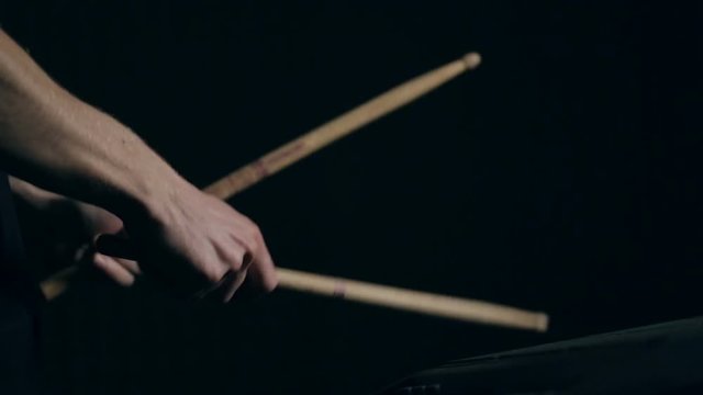 Close up shot of man's hands drum sticks on sampler and electronic pads