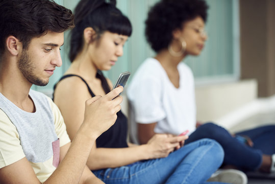 Students killing time with smartphones between classes