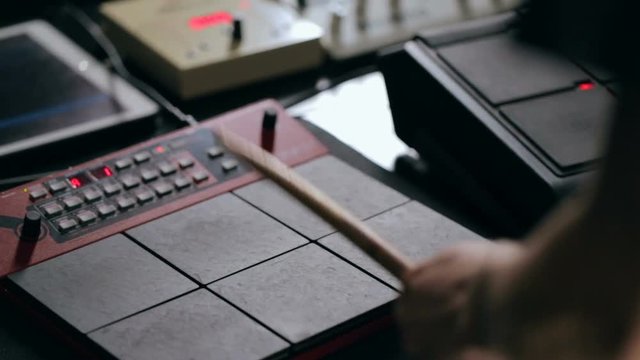 Close up shot of man's hands drum sticks on sampler and electronic pads