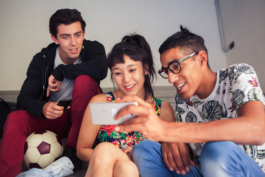 School friends looking at smartphone together