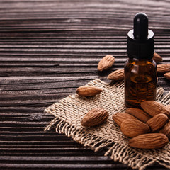 Fototapeta na wymiar almond essential oil on a wooden background