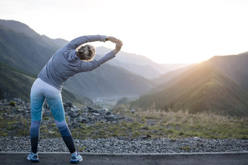 Athlete at the top of the mountain doing workout.