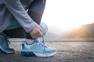 Sport runner woman tying laces before training. Marathon.