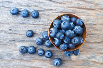 Blueberries in wooden bowls on wooden background