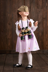 child girl are dressed as soldier in retro military harrison cap and pink dress