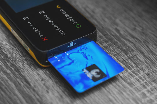 Credit card reader with a blue credit card inserted. Credit card terminal with touch screen.