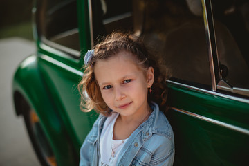 Smiling little girl playing near the old fashion car - 208748526