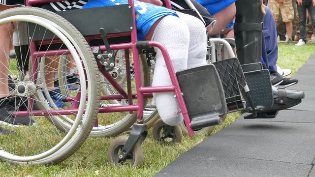 Army veterans without legs or with leg prostheses with disabilities at wheelchair outdoor