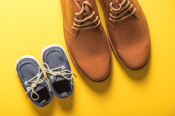 father and son shoes on yellow background , father day concept - Powered by Adobe