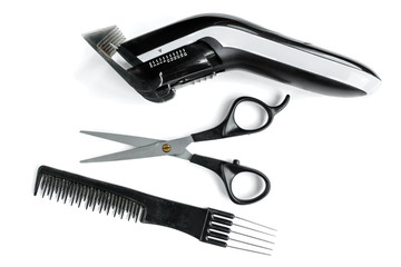 Black hair scissors, comb and hair clipper isolated on white background.