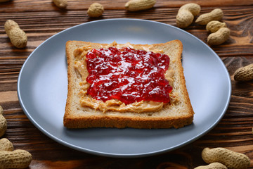 Peanut butter and jelly sandwich on wooden background. Space for text or design.