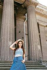 low angle view of beautiful girl in hat standing on stairs and looking away