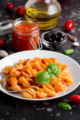 Italian shell pasta with tomato sauce, olives and Basil, classic food