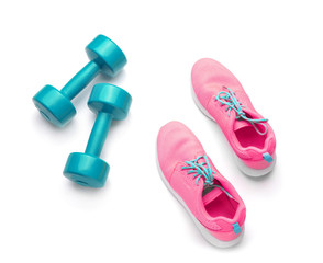 Dumbbells and sneakers on white background