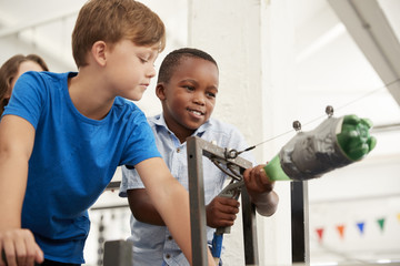 Two schoolboys using air pressure rocket at a science centre