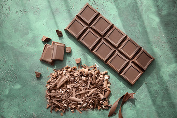 Delicious chocolate bar and shavings on table