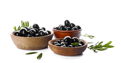 Bowls with black olives on white background
