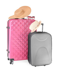 Suitcases, sunglasses and hats on white background