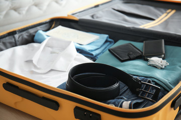 Open suitcase with packed things, closeup