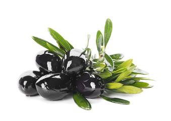 Black olives covered with oil and green leaves on white background
